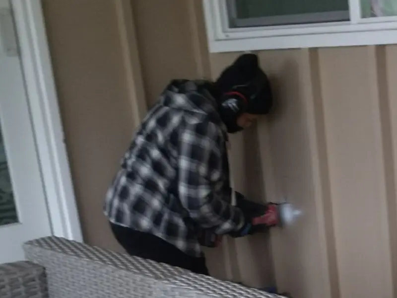 Professional electrician installing an exterior outlet in Acme